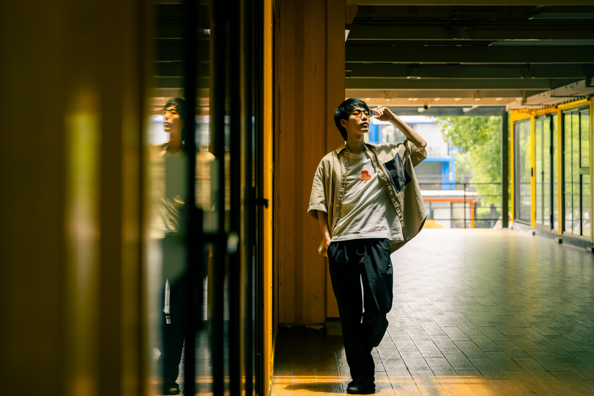 一名年轻男子走在建筑物内的走廊上