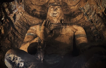 一尊佛像坐在大型洞穴里