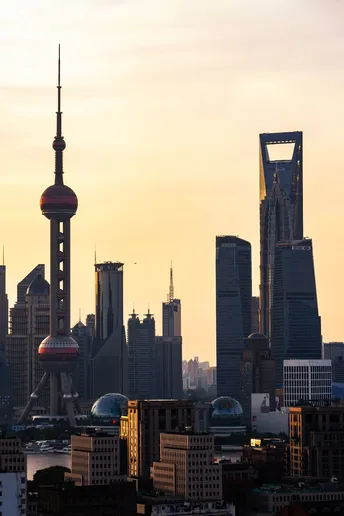 夕阳下的城市天际线 前景中有高楼大厦和摩天大楼。