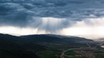 山谷上空乌云密布 山脉环绕 城市在云层之上。