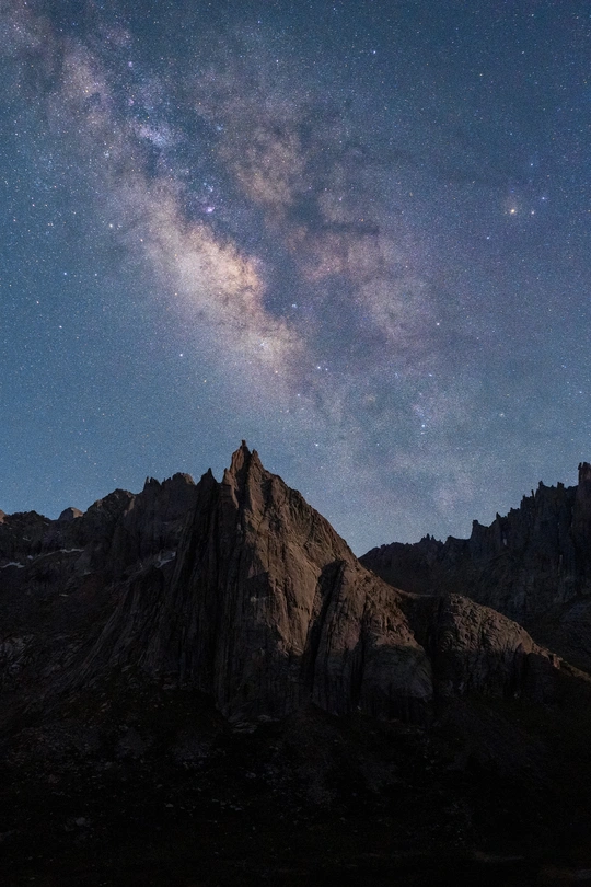 夜晚的山脉上有星星和星系在天空中。