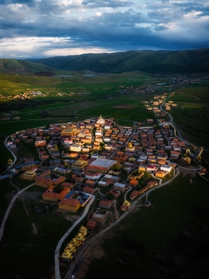 傍晚或夜晚的小镇或村庄的 aerial view 背景是山脉。