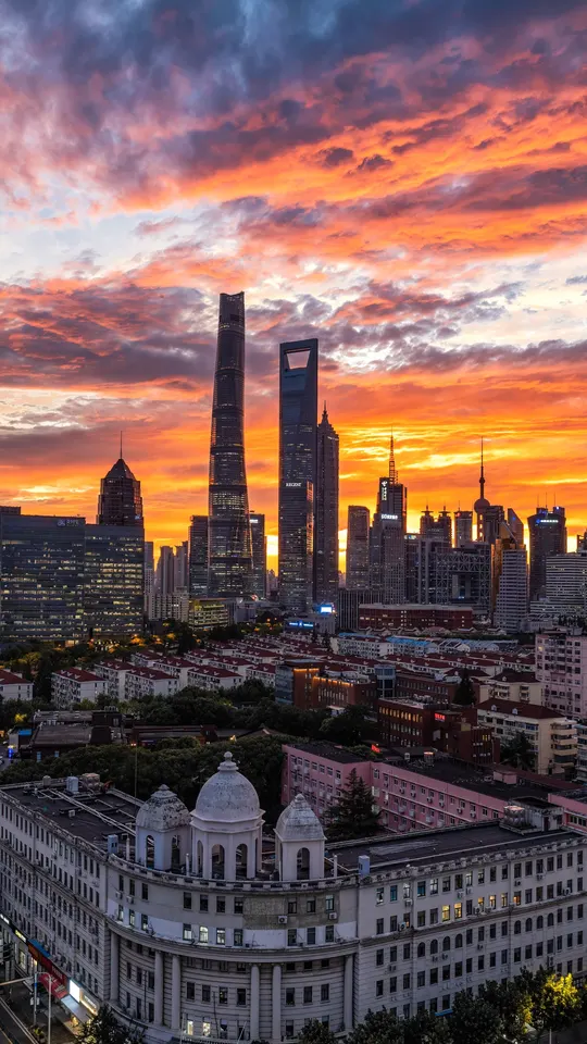 夕阳下的城市 太阳正在落下 前景中有建筑。