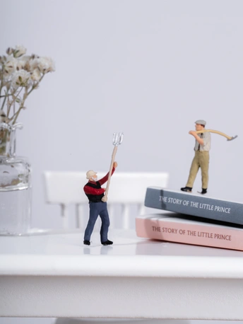 一堆书上的几个小人物的小雕像