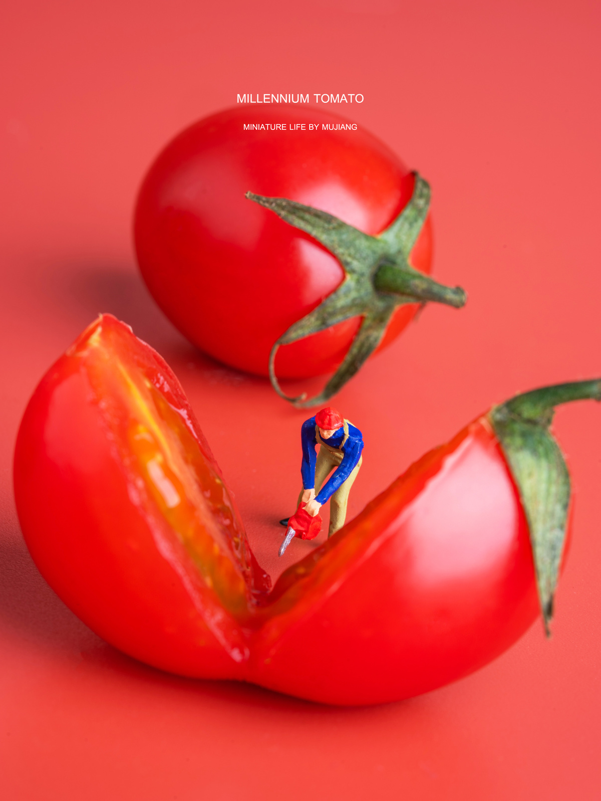 一个站在红色背景上的人物迷你塑像 旁边有一个在番茄上的小人塑像。