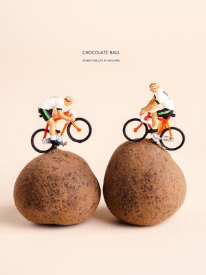 小人骑自行车在岩石顶部的一个广告