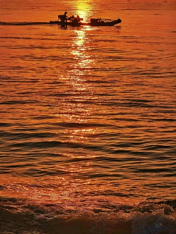 夕阳下 小船中的人们