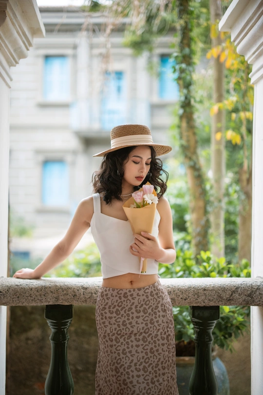 一个戴着帽子拿着花的年轻女子