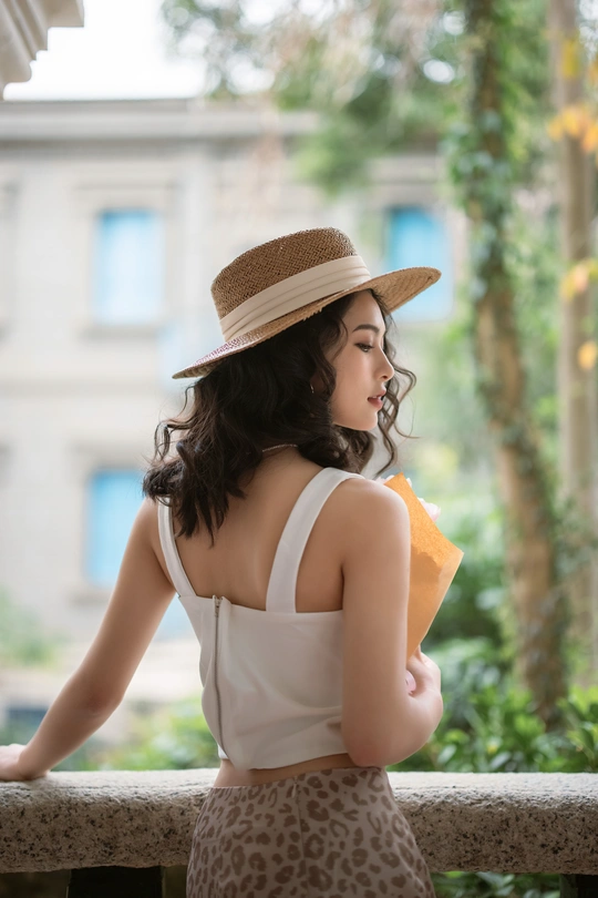 一个戴着帽子的年轻女子站在阳台上