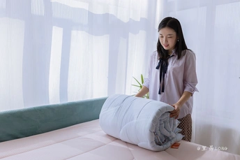 一位女士正在把枕头放在床上