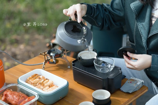 一个坐在桌子旁 碗里装着食物 手里拿着一杯茶的女人