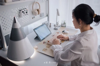 一位年轻女性坐在桌子前使用电脑工作
