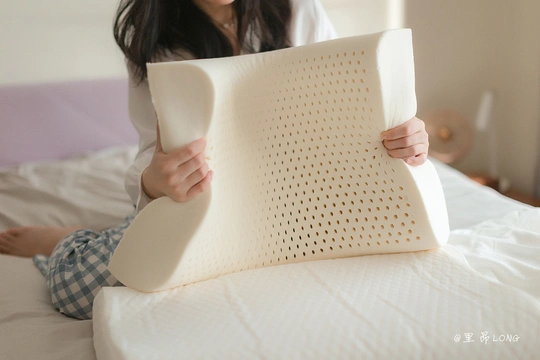 一个女性坐在床上抱着一个枕头