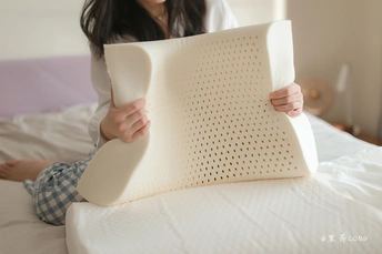 一个女性坐在床上抱着一个枕头