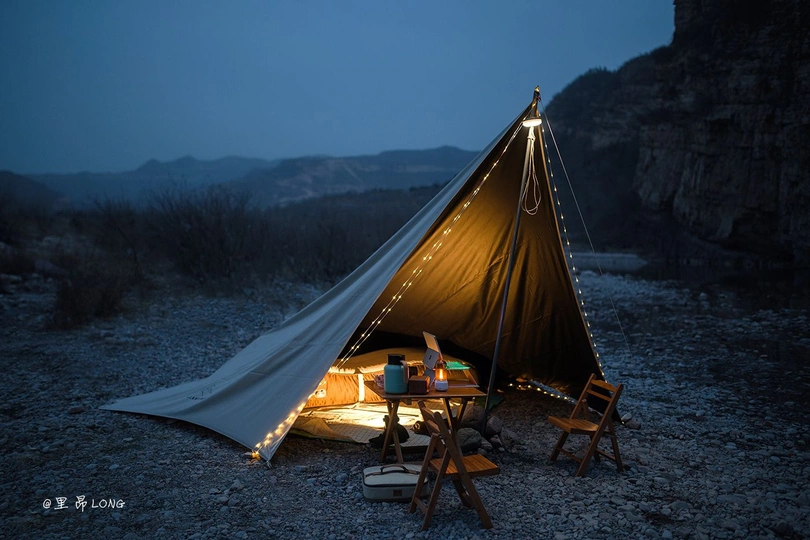 一个帐篷 夜晚有桌子和椅子在外