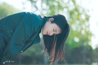 公园里一个年轻的美丽女人带着悲伤的表情和头