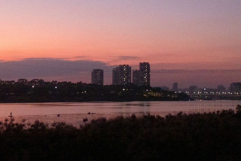 城市上空的粉红色天空和水上建筑的日落