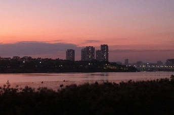 城市上空的粉红色天空和水上建筑的日落