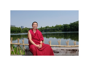 一位僧人坐在湖边的一张照片