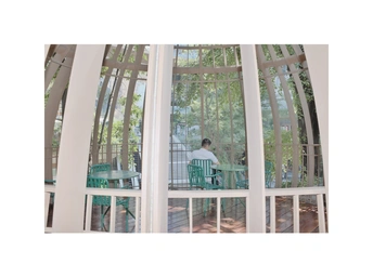 一张带有大窗户的房子内部照片 一个人坐在桌子旁