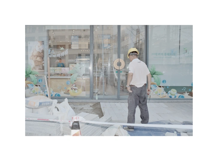 一个戴帽子的人在窗户前站立