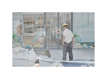 一个戴帽子的人在窗户前站立