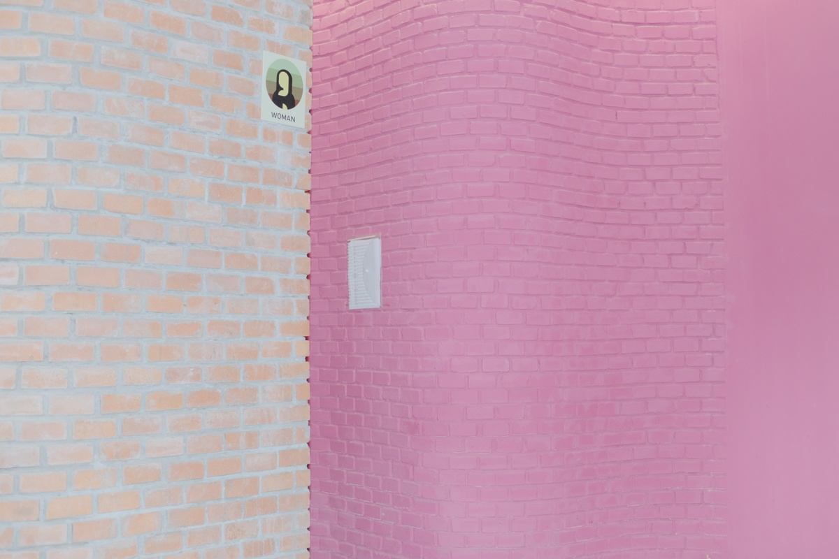 一个带有粉红色砖墙和粉红色马桶的浴室
