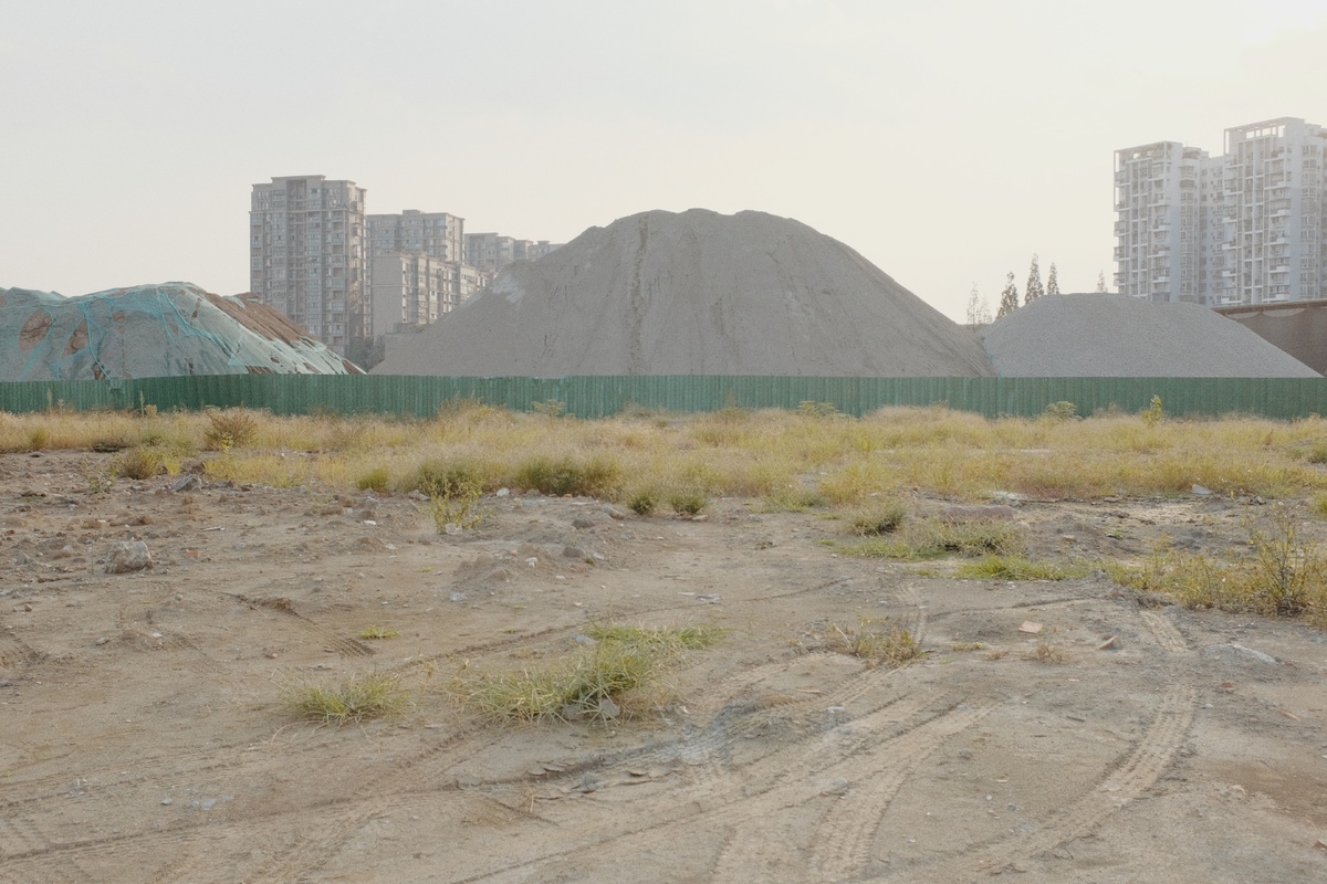 背景是土丘和沙堆 前景是城市和建筑。