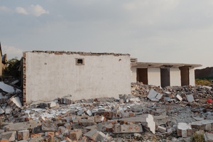 周围有许多碎屑的房屋和前景中的墙
