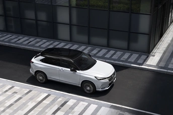 一辆白色SUV在靠近建筑物的街道上行驶