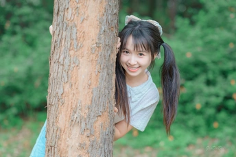 一个小女孩在森林里拥抱一棵树
