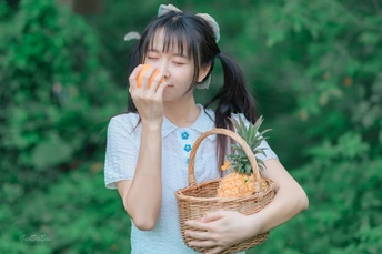 一个年轻女孩拿着装满苹果和桔子的篮子