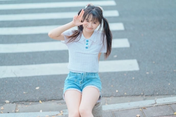 一个小女孩站在人行横道前的人行道上