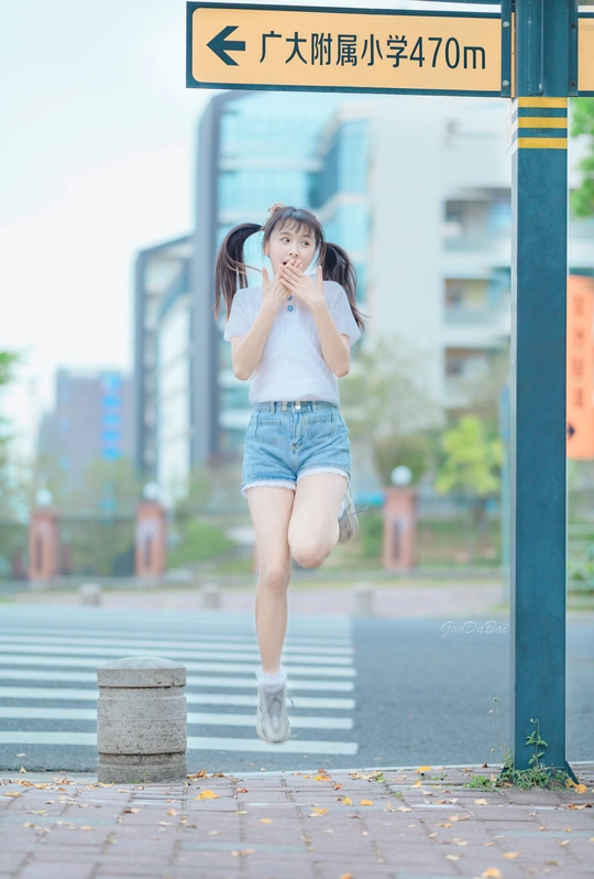 一个小女孩在街上跳到空中