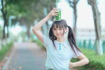 一个年轻女孩手里拿着一杯水 头上戴着一个绿色的杯子