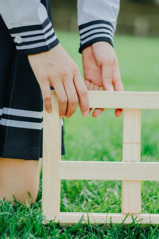 一个小孩子正在草地上玩一个木制游戏