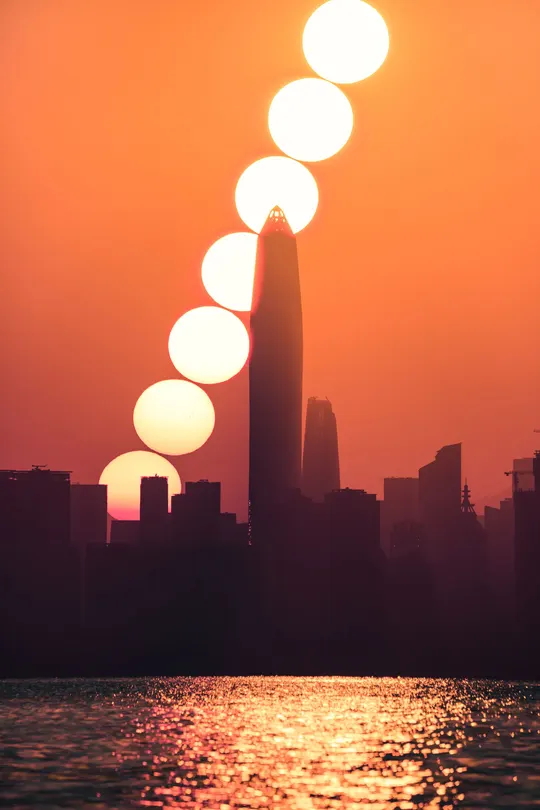 太阳落在了城市的地平线上 前景中有建筑物。