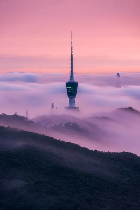 云雾缭绕的城市 山顶有一座塔。