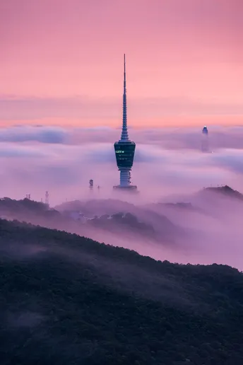 云雾缭绕的城市 山顶有一座塔。