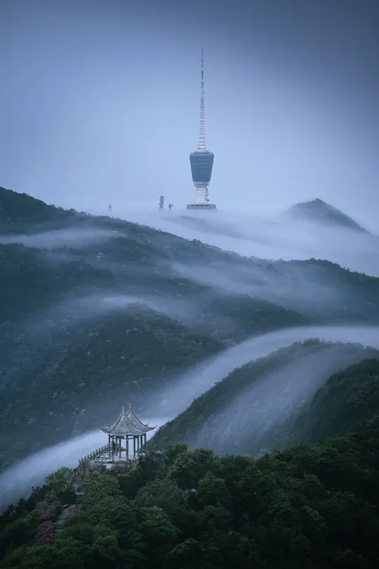 云雾缭绕的山谷中的山顶一座宝塔