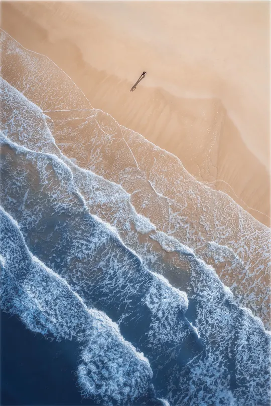 空中俯瞰一艘飞越沙滩和海洋波浪的船