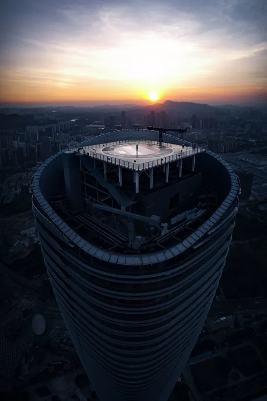 夕阳西下 太阳在傍晚时分从高楼的顶部落下 映照在城市的上空。