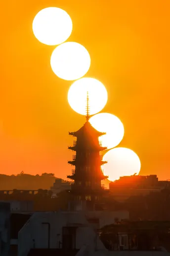 城市上空出现日食 太阳从塔后升起