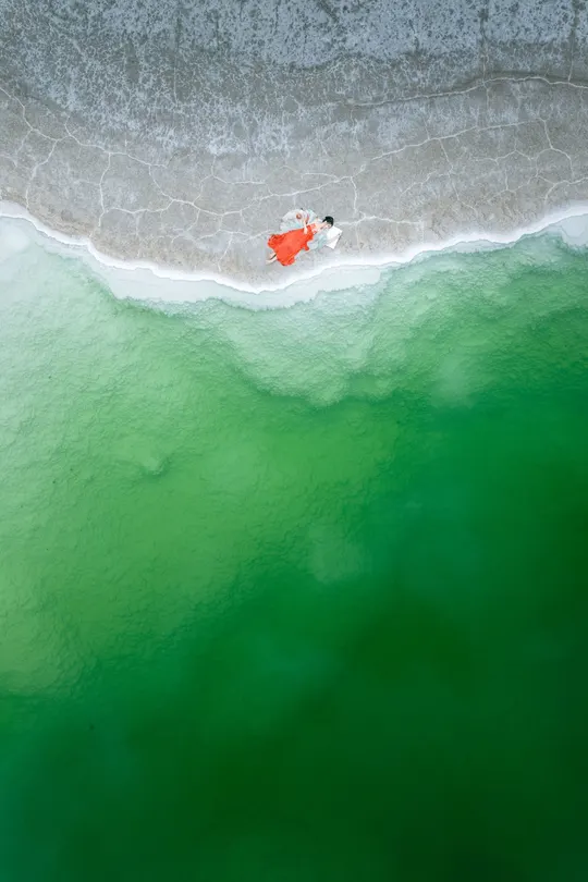 海上的一张沙滩照片 人们在水里游泳 一艘船在海洋中。