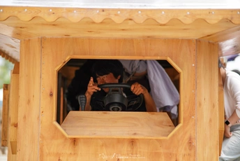 一个带着相机的男人在一个木制狗屋中拍照