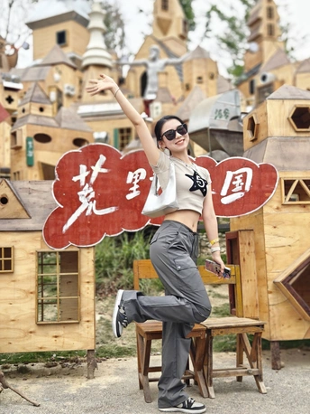 一位女性在木制标志前摆姿势