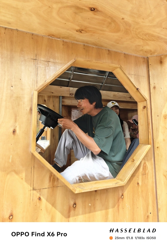 一位在树上建房子的人 房子有一个用来做窗户的洞。