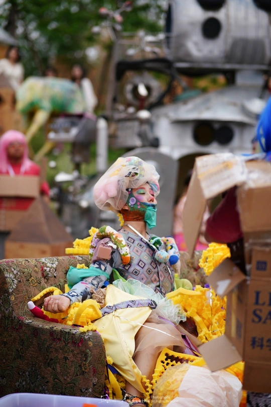 一个坐在花丛中的小丑雕像