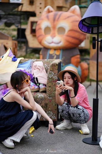 一些年轻女孩坐在人行道上玩手机