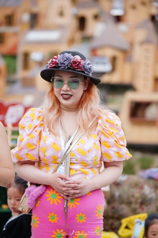 一位戴着花帽子、太阳镜参加节日的女士